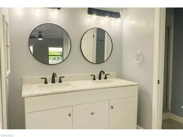 Bathroom featuring double vanity and a ceiling fan