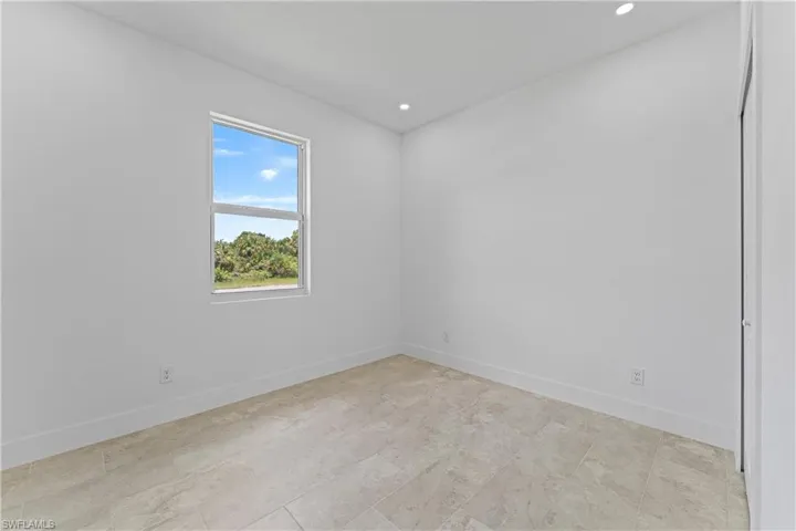 Spare room featuring baseboards and recessed lighting