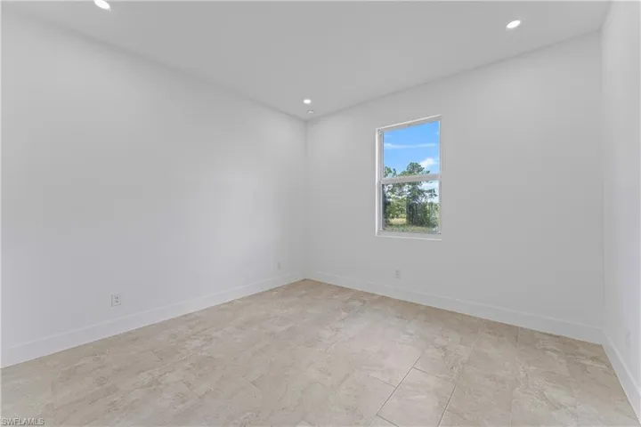 Empty room with recessed lighting and baseboards
