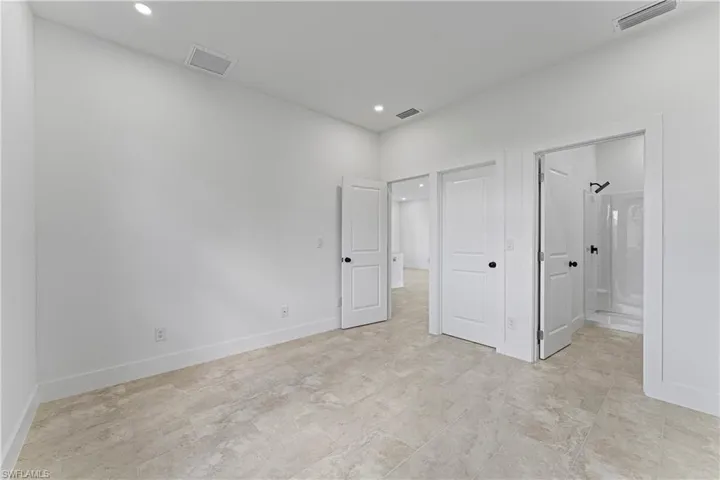 Unfurnished bedroom with recessed lighting and ensuite bath