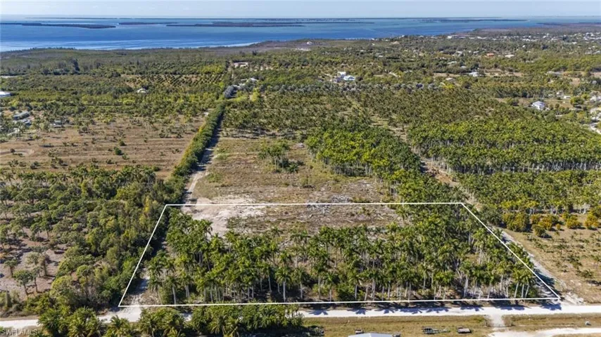 Overview of rural landscape with property parcel outlined and a nearby body of water