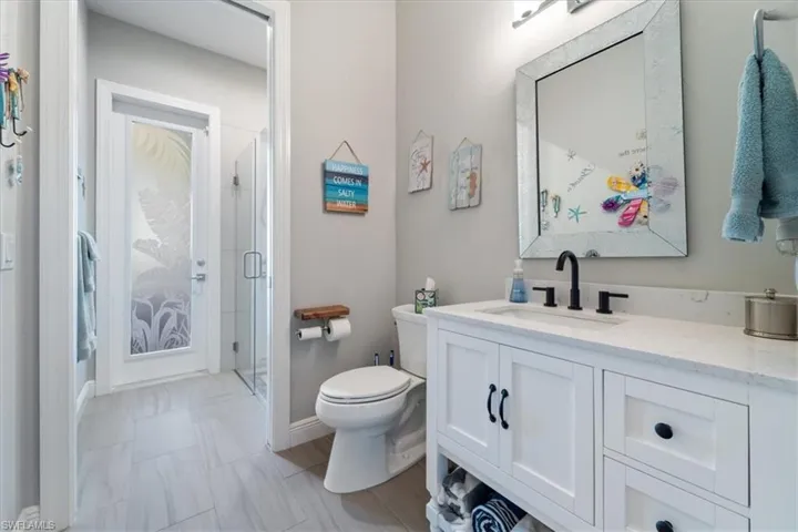 Full bathroom3 with toilet, vanity, baseboards, and a shower stall
