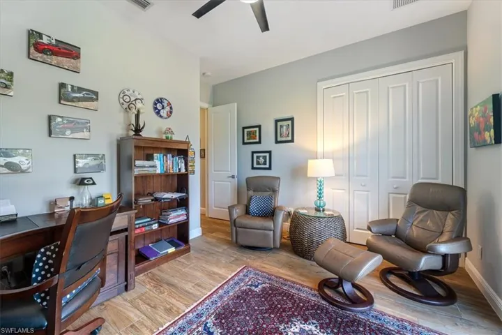Office area with a ceiling fan, baseboards, and light wood-style flooring