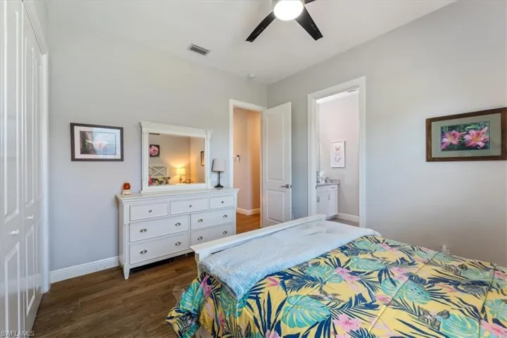 Bedroom2 with dark wood-style flooring, baseboards, ceiling fan, and visible vents
