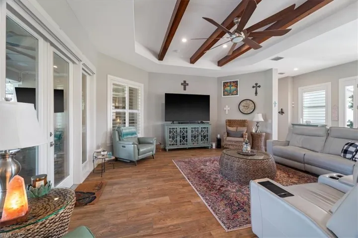 Living room with visible vents, beamed ceiling, wood finished floors, recessed lighting, and a ceiling fan