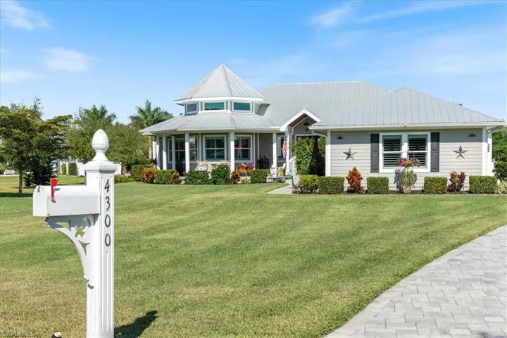 View of front facade with metal roof and a front lawn