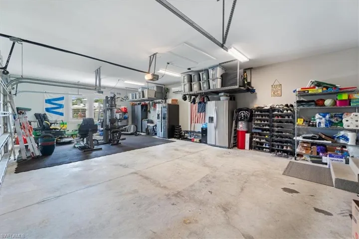 Garage with a garage door opener and stainless steel fridge