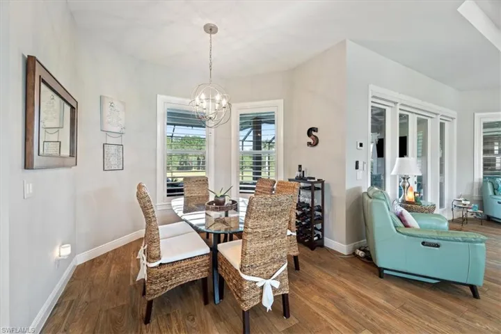 Dining area featuring a notable chandelier, baseboards, and wood finished floors