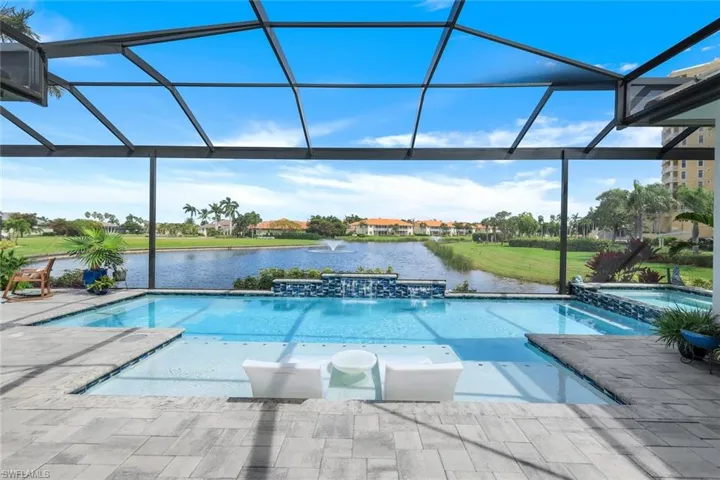 View of pool with no see em panoramic enclosure, an in ground hot tub, a water view, and a patio area
