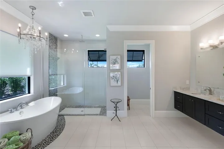 Bathroom featuring vanity, shower with separate bathtub, tile patterned flooring, and crown molding