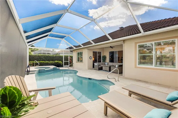 View of pool with a patio, a lanai, outdoor lounge area, a pool with connected hot tub, and a ceiling fan