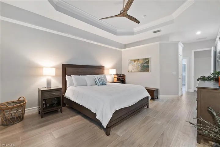 Bedroom with crown molding, a tray ceiling, and ceiling fan