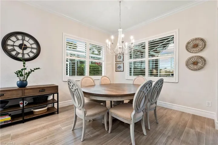 Dining room featuring an inviting chandelier, light hardwood / wood-style floors, and crown molding