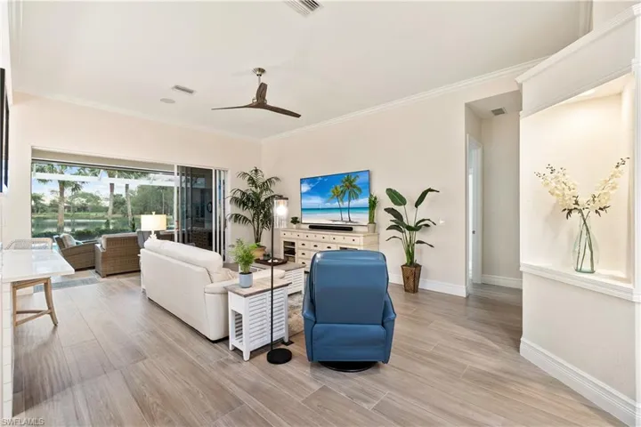Living room with crown molding and ceiling fan