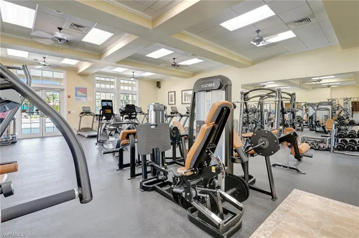 Exercise room featuring visible vents, crown molding, and a ceiling fan