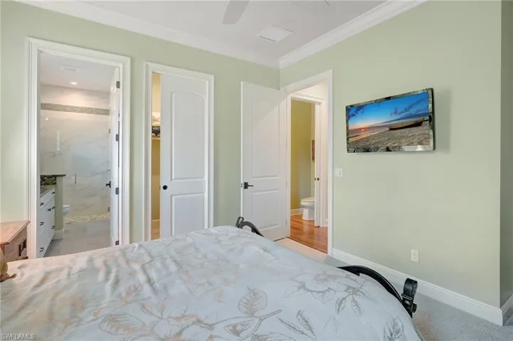 2nd bedroom, ensuite bath, ornamental molding, and ceiling fan and walk-in closet