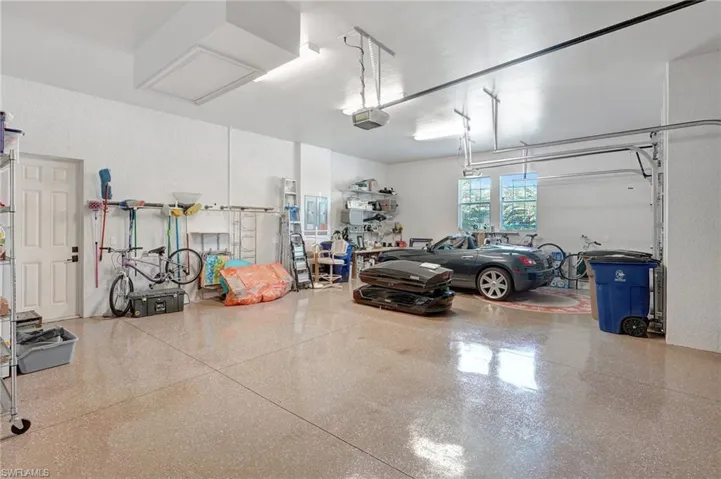 3 car Garage featuring epoxy flooring, lots of storage and secured closet