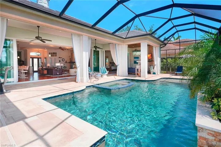 View of pool  and seamless connection to indoor living space, featuring outdoor lounge area, lights on screens