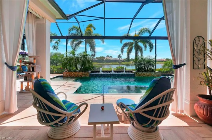View of swimming pool with a water view, a lanai, and a patio area