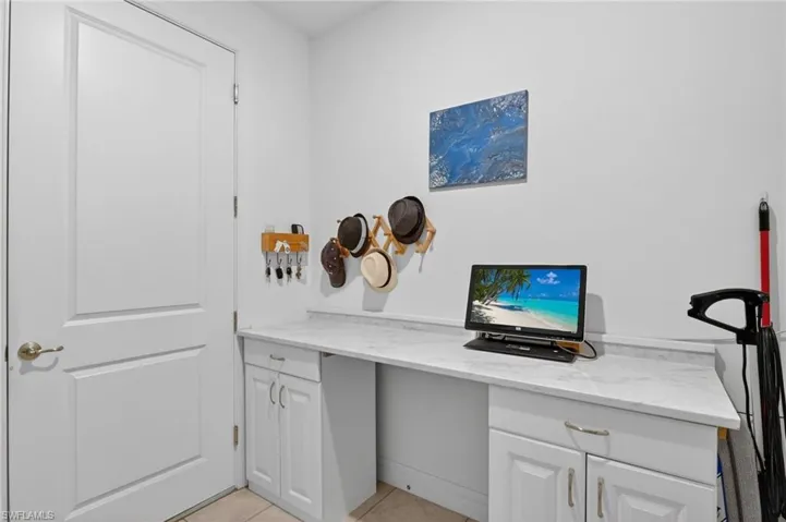 Step into a functional and inviting laundry room, complete with a stylish work desk and ample cabinetry for all your storage needs!