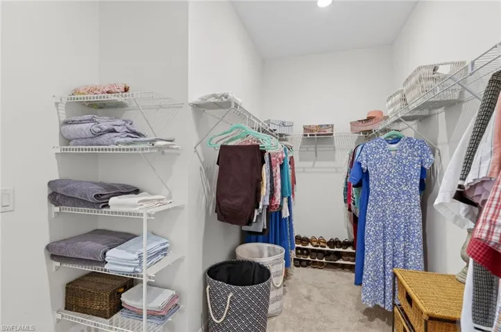 Huge Walk-in closet with light colored carpet