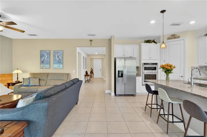 Experience the charm of this wonderful room, offering a captivating view of the kitchen dining area and access to a cozy covered lanai, perfect for enjoying leisurely moments or entertaining friends!