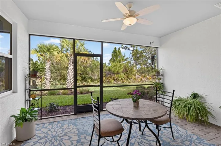 Covered screened lanai with a ceiling fan, outdoor dining space, and a patio area