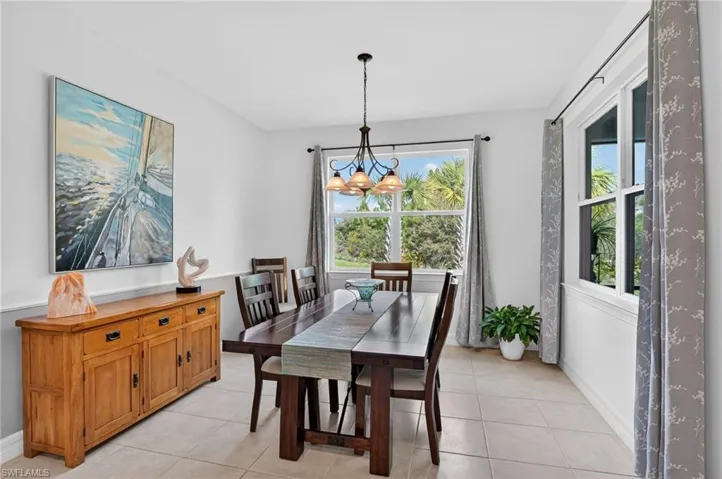 Step into a dining area, featuring a stunning chandelier that casts a warm glow overhead. The light-patterned tile floors add a touch of sophistication, creating an inviting atmosphere perfect for memorable gatherings.