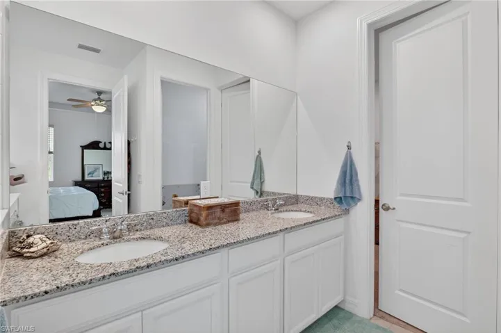 Step into a luxurious full bath that boasts a stunning double vanity, This retreat features an ensuite bathroom for added privacy and convenience, along with a sleek oversized walk-in shower stall that promises refreshing moments. The light tile patterned floors add a touch of elegance, creating a bright and inviting atmosphere that transforms your daily routine into a spa-like experience.