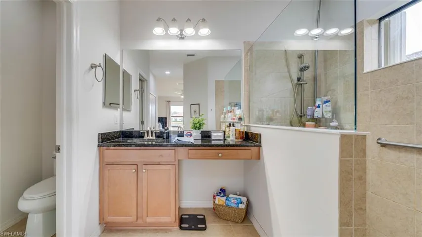 Bathroom with vanity, walk in shower, and light tile patterned floors