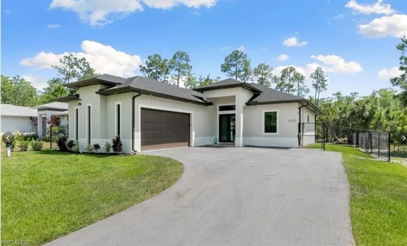 Prairie-style home featuring a garage and a front lawn