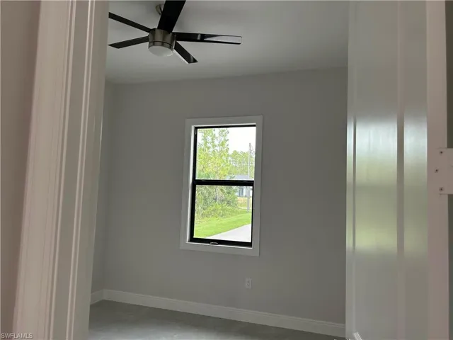 Spare room featuring ceiling fan and concrete flooring
