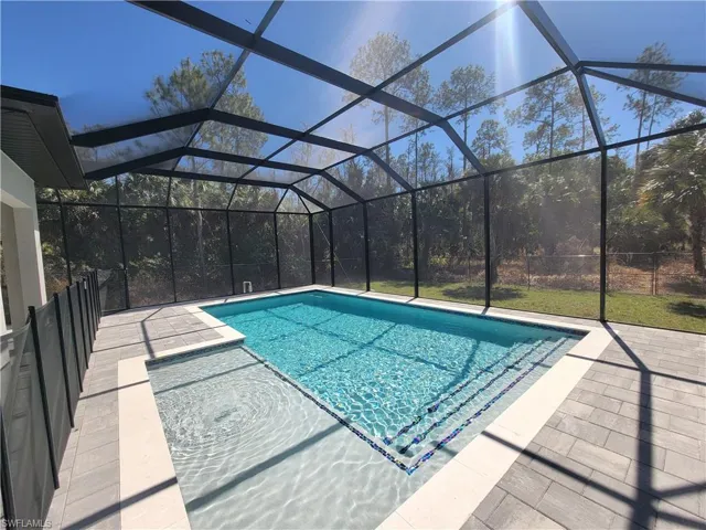 Outdoor pool with a sunroom, a lanai, and a patio