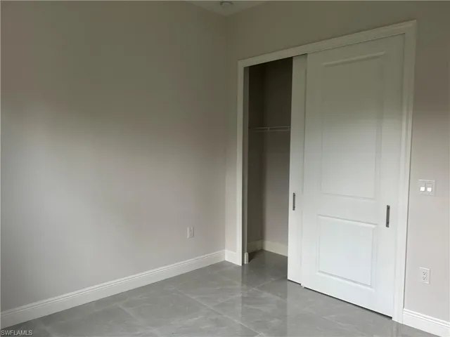 Unfurnished bedroom featuring a closet and light tile patterned floors