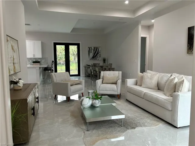 Tiled living room featuring a raised ceiling