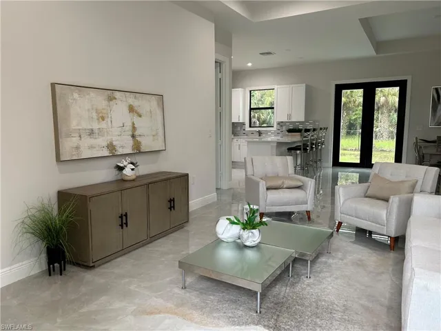 Sitting room with a wealth of natural light, light tile patterned floors, and sink