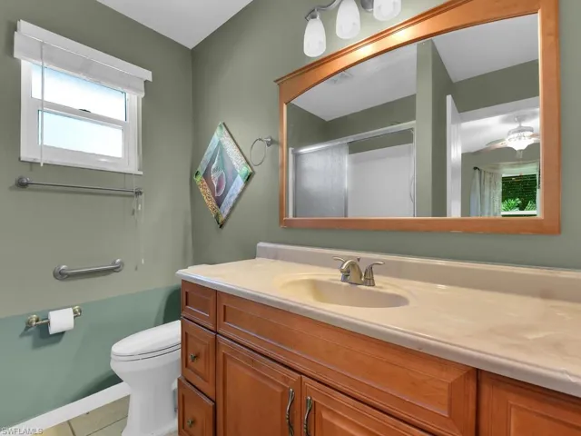 Full bath featuring toilet, vanity, visible vents, and a shower stall