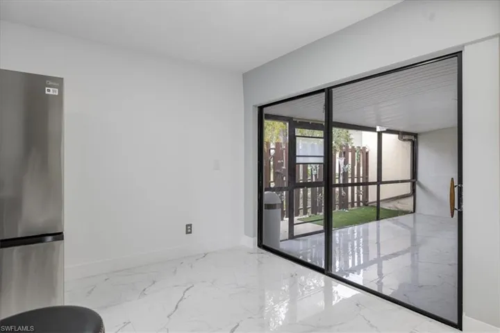 Empty room featuring baseboards and marble tiled floors