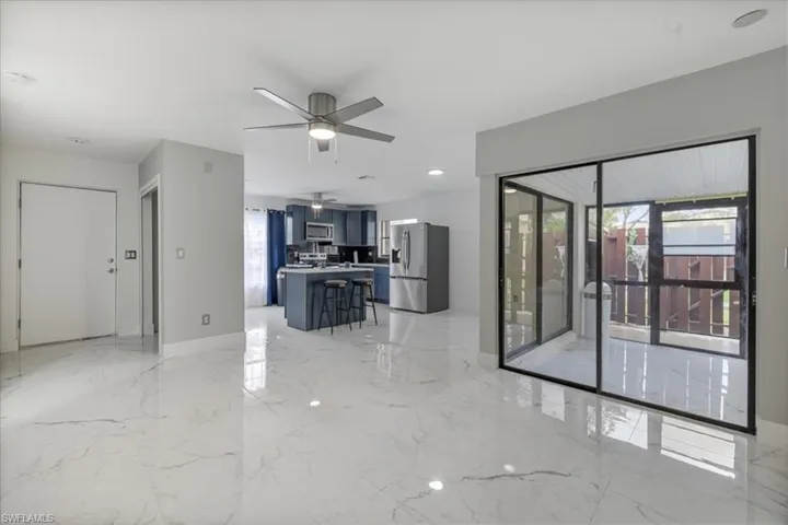Living area featuring light marble finish flooring, a ceiling fan, and recessed lighting