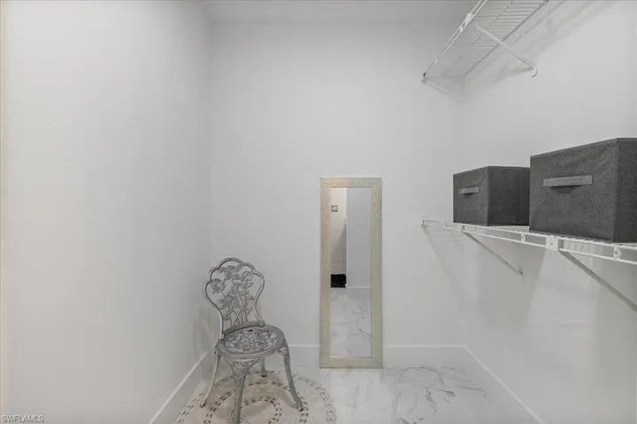 Walk in closet featuring light marble finish flooring