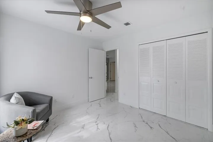 Living area featuring baseboards and light marble finish floors