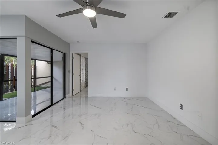 Spare room featuring light marble finish floors and a ceiling fan