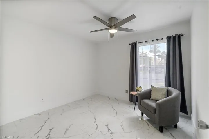 Sitting room featuring light marble finish flooring and ceiling fan