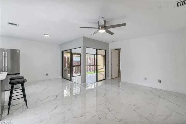 Spare room with light marble finish floors and a ceiling fan