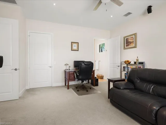 Spacious room with light neutral carpeting, recessed ceiling lighting, a ceiling fan, and multiple paneled doors