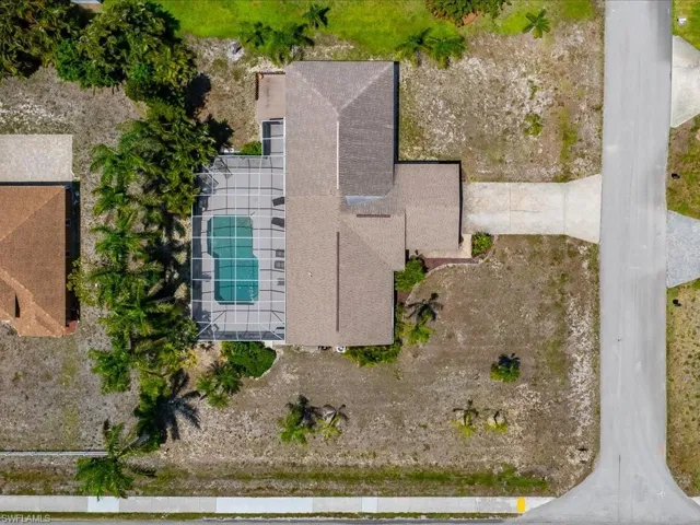 Aerial view showcasing a property with a screened swimming pool