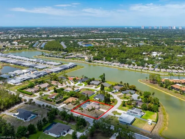 Aerial perspective showcasing the property with a private pool, surrounded by mature trees and manicured landscaping