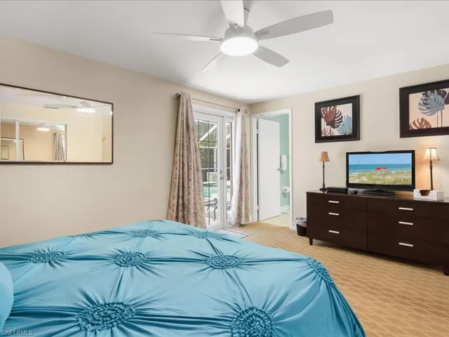 Room featuring a ceiling fan with integrated lighting, glass-paned double doors, and light-colored walls
