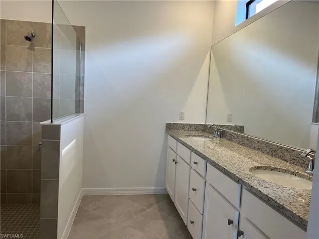 Bathroom featuring a walk in shower and double vanity