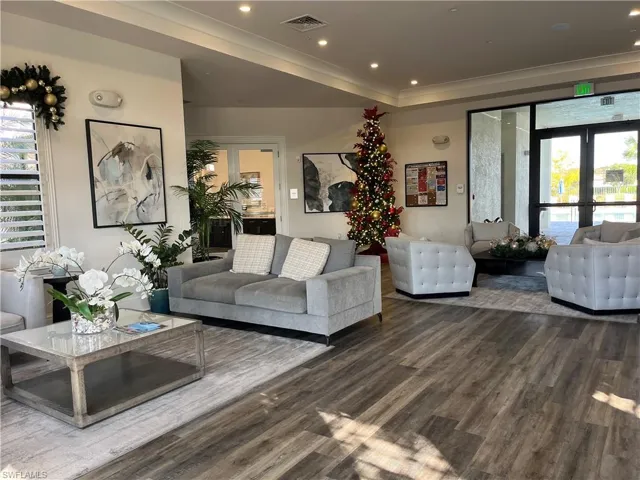 Living area featuring french doors, wood finished floors, crown molding, and recessed lighting